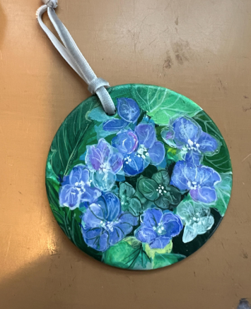 Round decorative item with blue flowers on a brown surface
