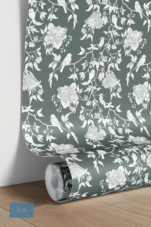 Roll of wallpaper with white floral and bird pattern on a dark green background