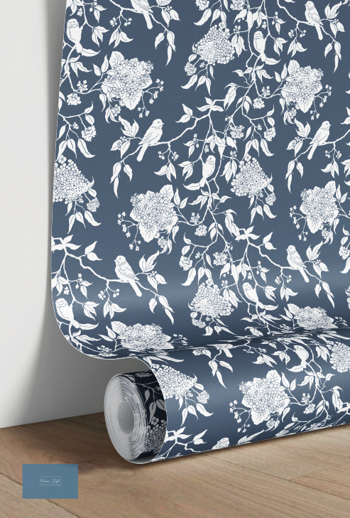 Roll of wallpaper with white floral and bird pattern on a blue background