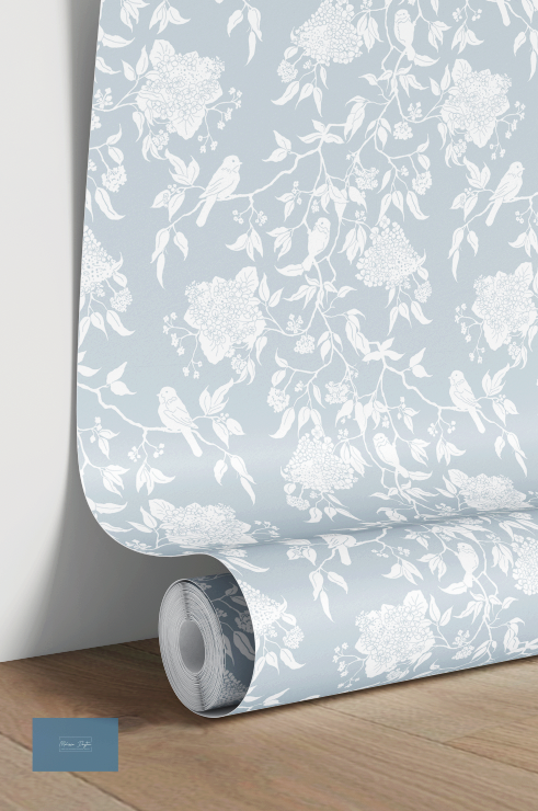 Roll of floral wallpaper with white flowers and birds on a light blue background