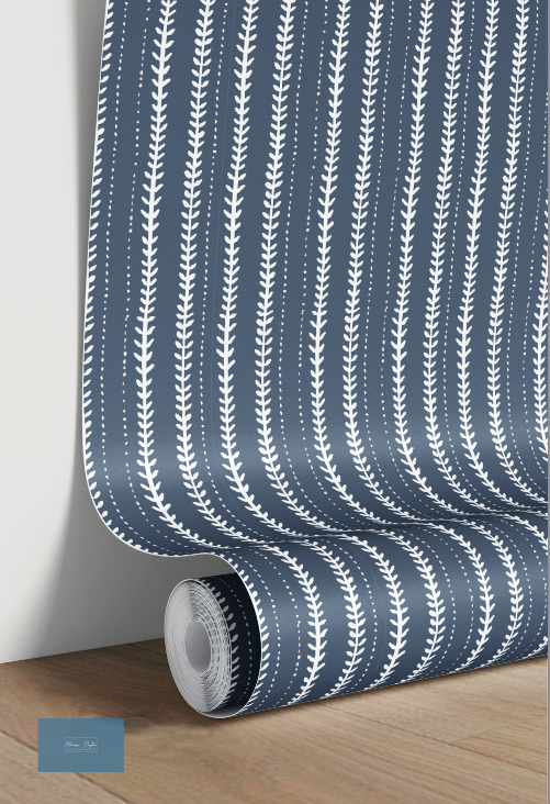 Roll of blue wallpaper with white leaf pattern on a wooden surface.