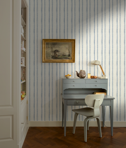 Home office with striped wallpaper, desk, and chair.