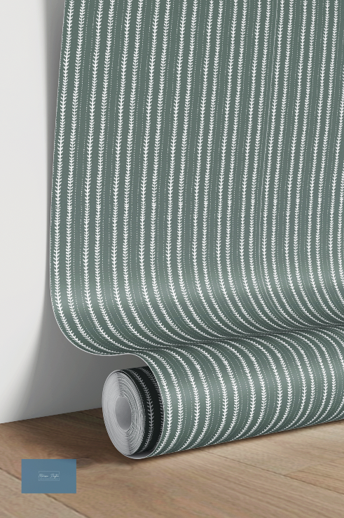 Roll of green and white striped wallpaper on a wooden surface with a light gray wall background.