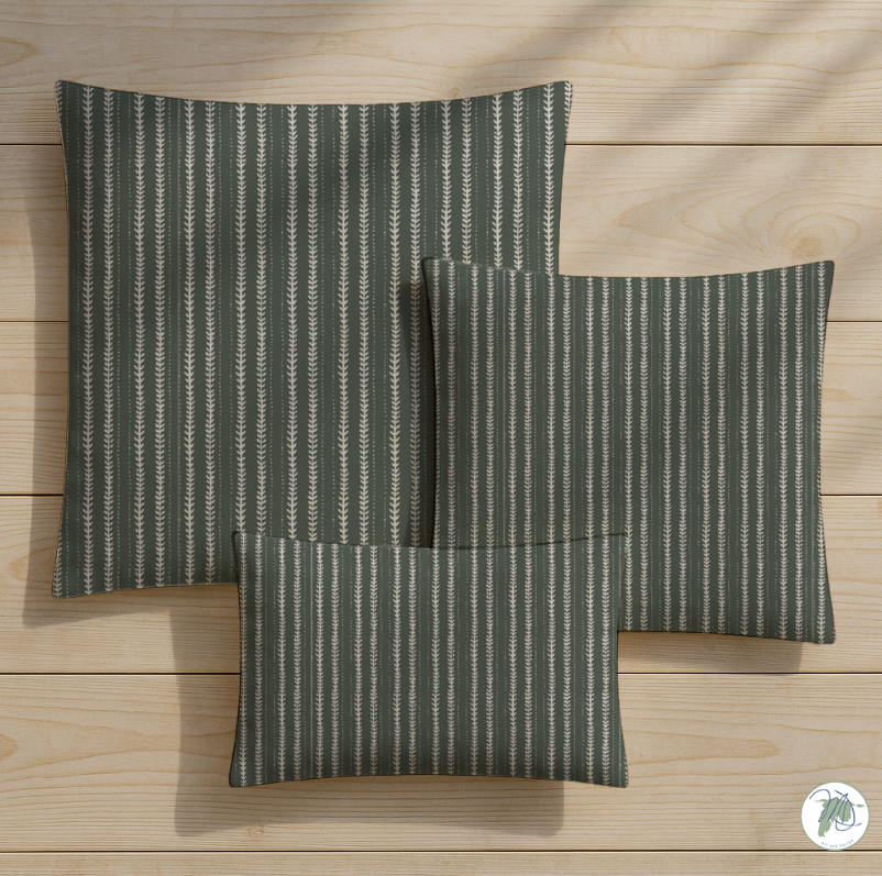 Three green striped pillows on a wooden surface
