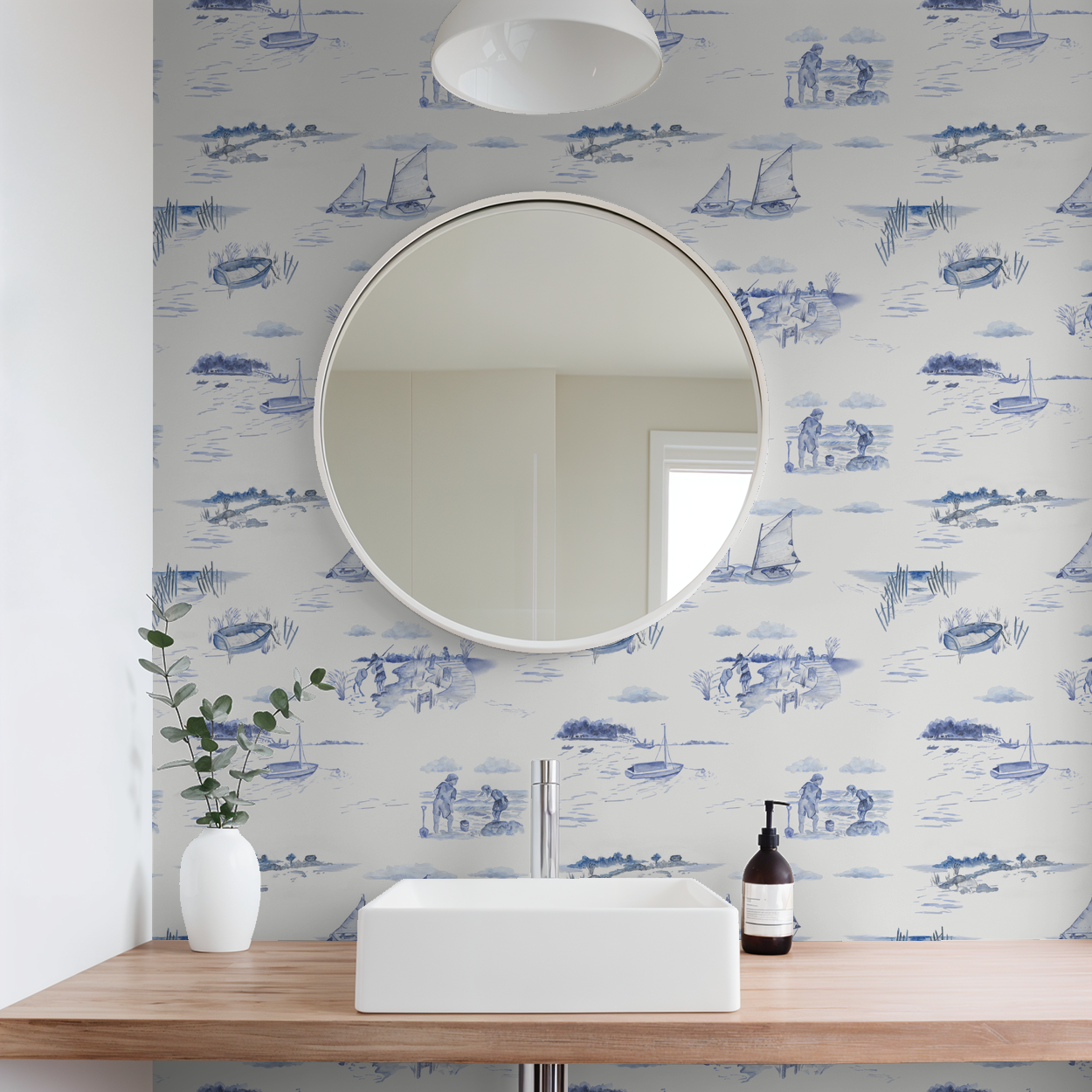Bathroom with round mirror, sink, and decorative wallpaper featuring blue patterns.
