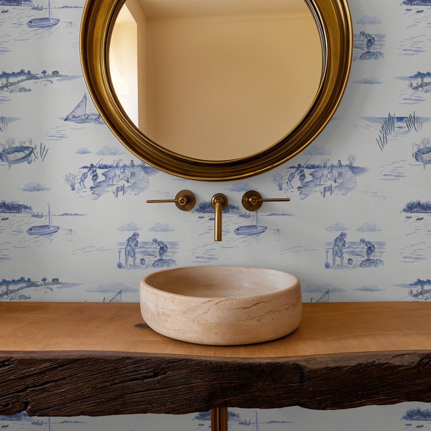 Bathroom vanity with stone sink, gold faucet, and round mirror against a decorative wallpaper.