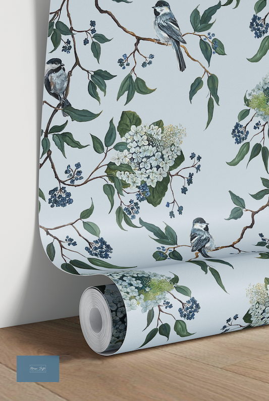 Roll of wallpaper with floral and bird design on a light blue background