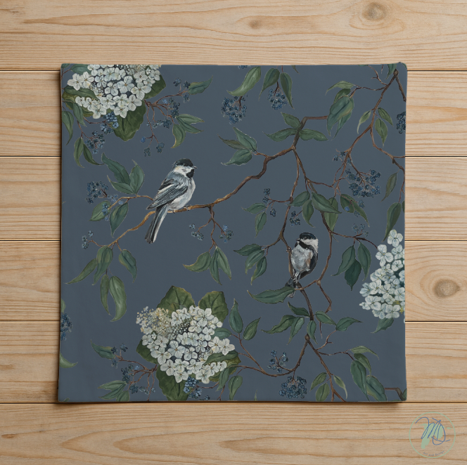 Decorative mat with birds and floral design on a wooden surface