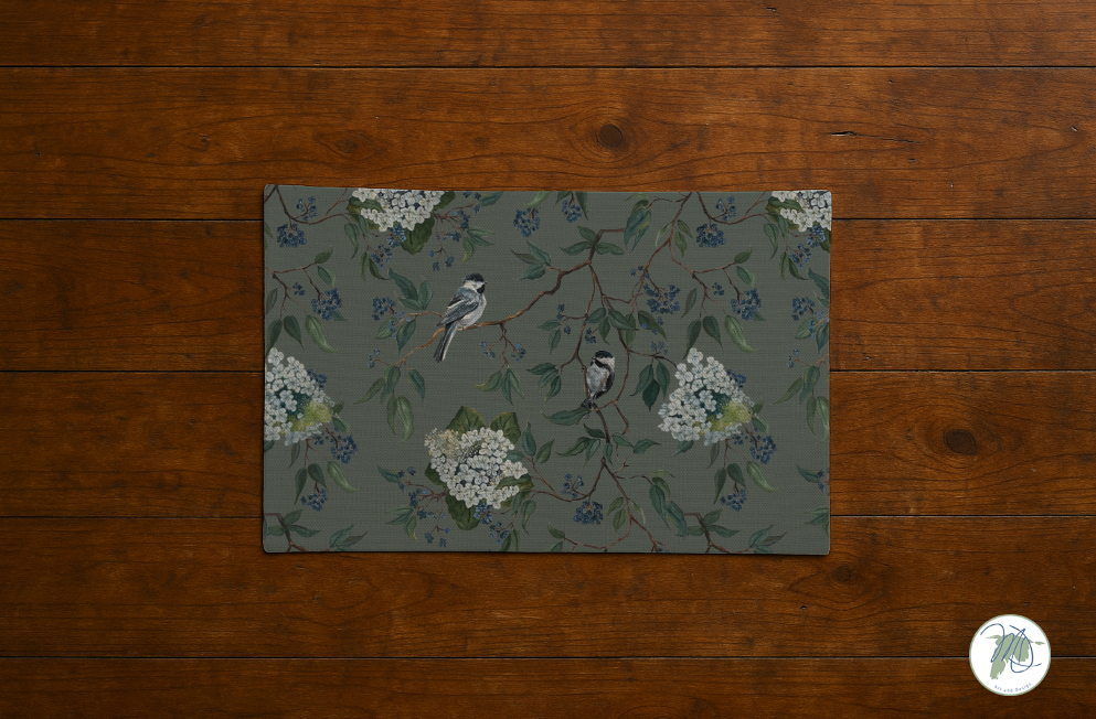Placemat with floral and bird design on a wooden surface