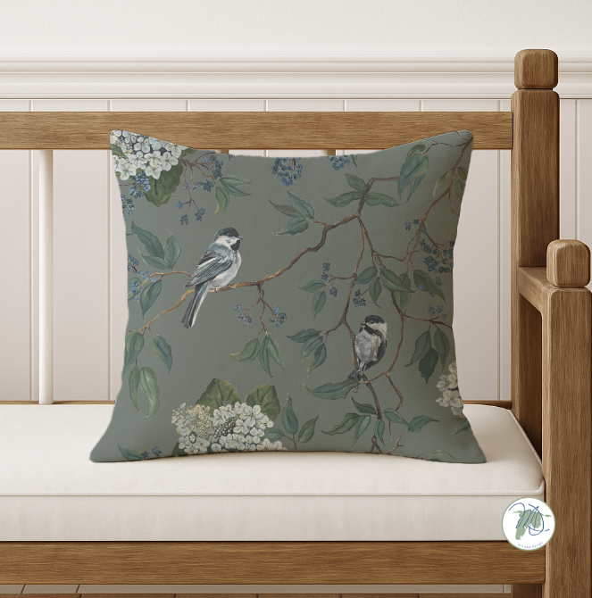 Decorative pillow with bird and floral pattern on a wooden bench
