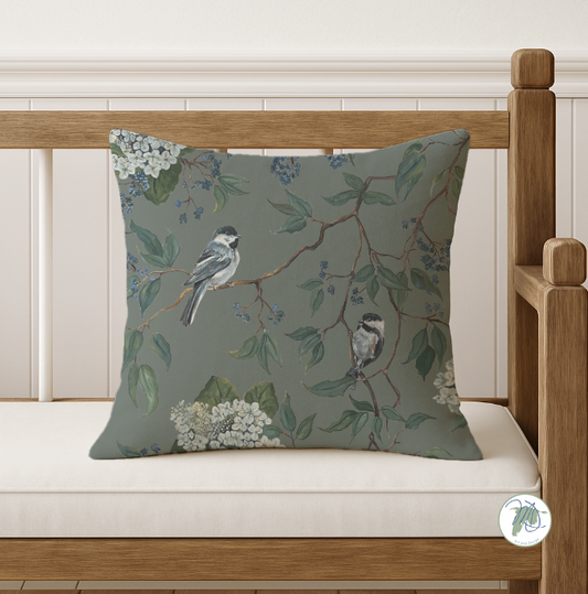 Decorative pillow with bird and floral pattern on a wooden bench