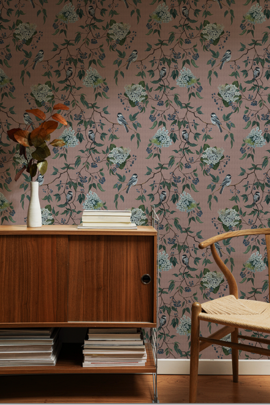 Room interior with floral wallpaper, wooden cabinet, and chair.