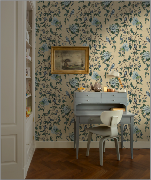 Room interior with floral wallpaper, desk, and chair.
