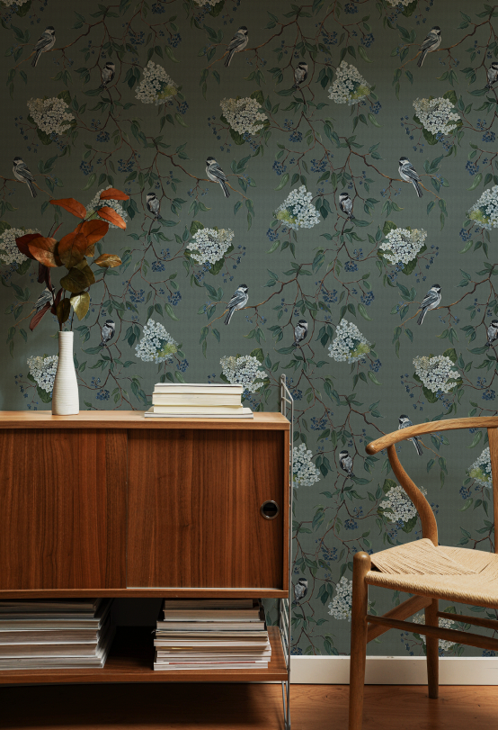 Room interior with wooden cabinet, chair, and floral-patterned wallpaper.