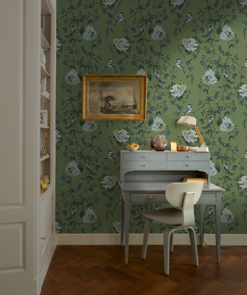 Room interior with floral wallpaper, desk, and chair.
