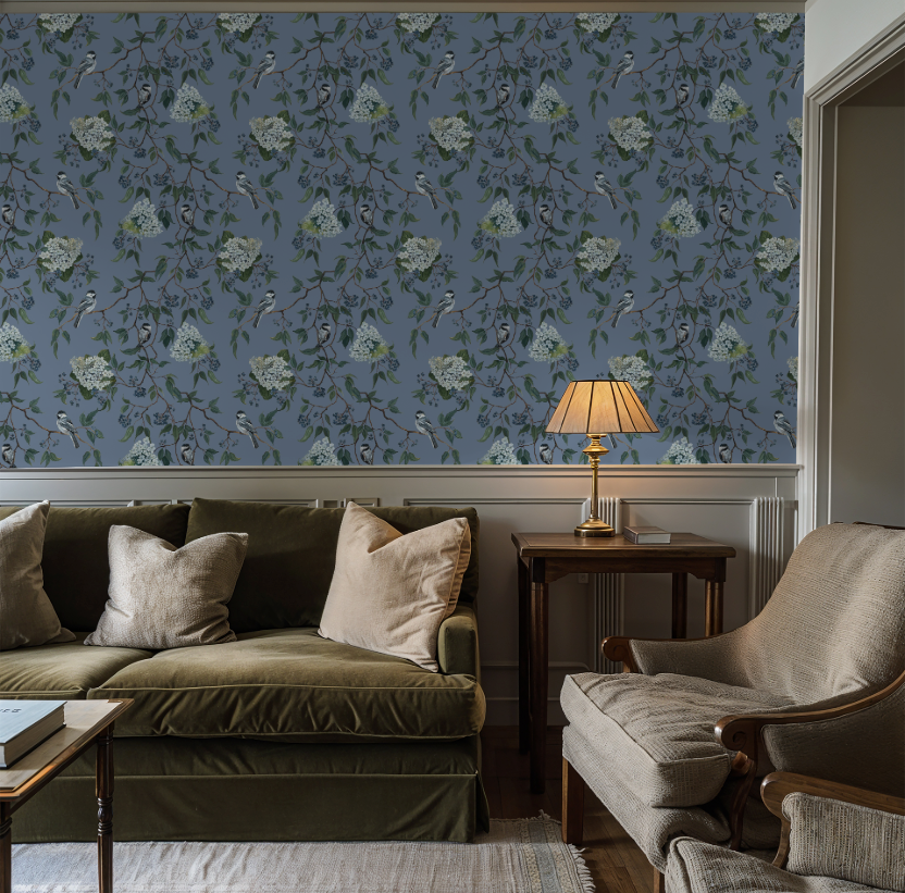 Living room with floral wallpaper, green sofa, and armchair.