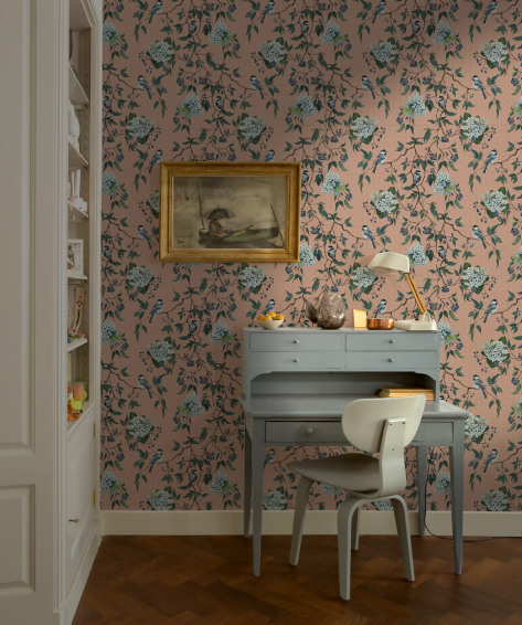 Room interior with floral wallpaper, desk, and chair.