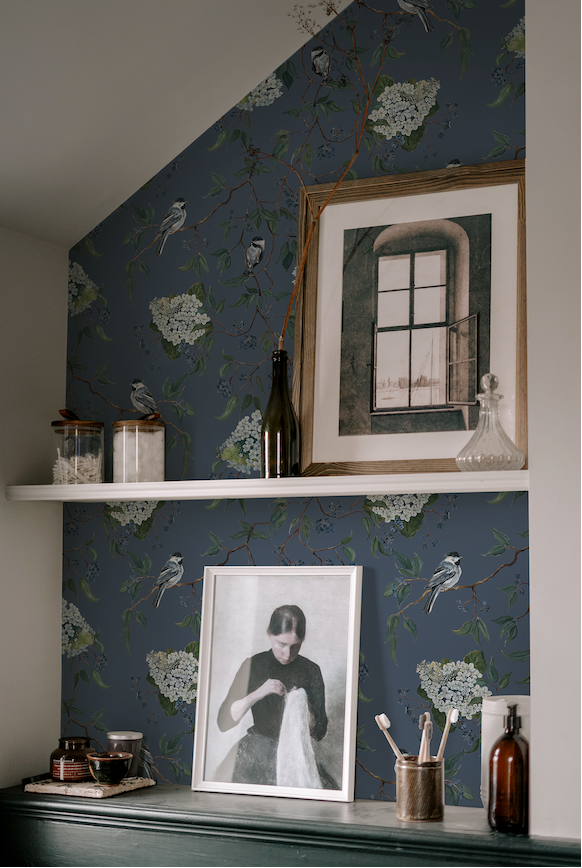 Niche with decorative items against a floral wallpapered wall