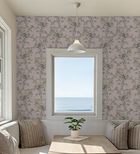 Living room with floral wallpaper, a window overlooking the ocean, and a plant on a table.