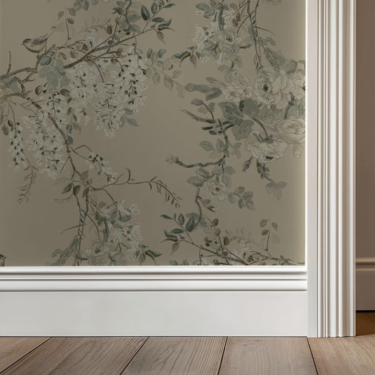 Floral wallpaper with greenery on a neutral wall with wooden flooring.