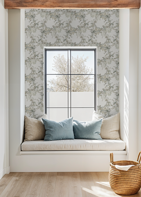 Window seat with cushions and a woven basket in a room with floral wallpaper.