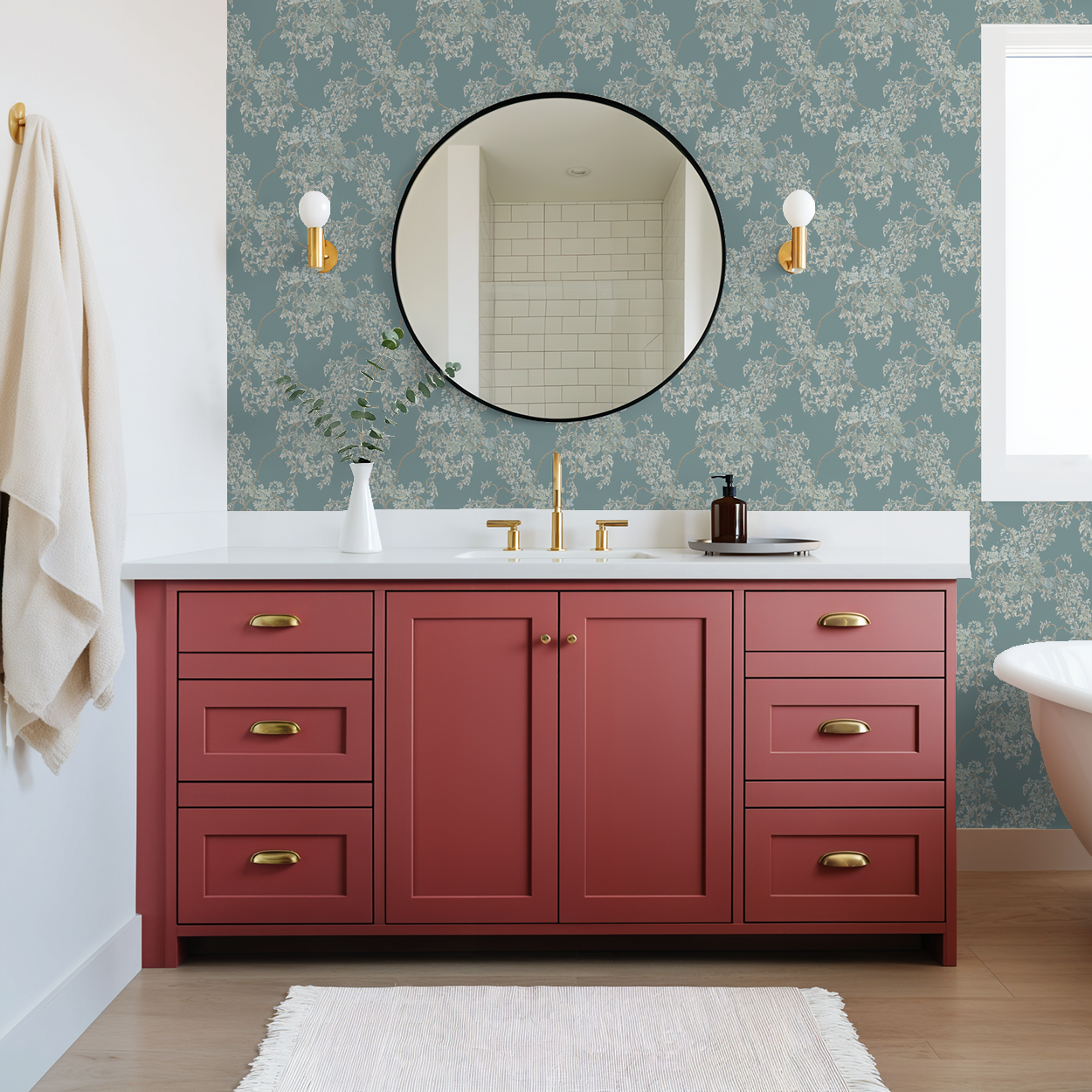 Bathroom with red vanity, round mirror, and floral wallpaper