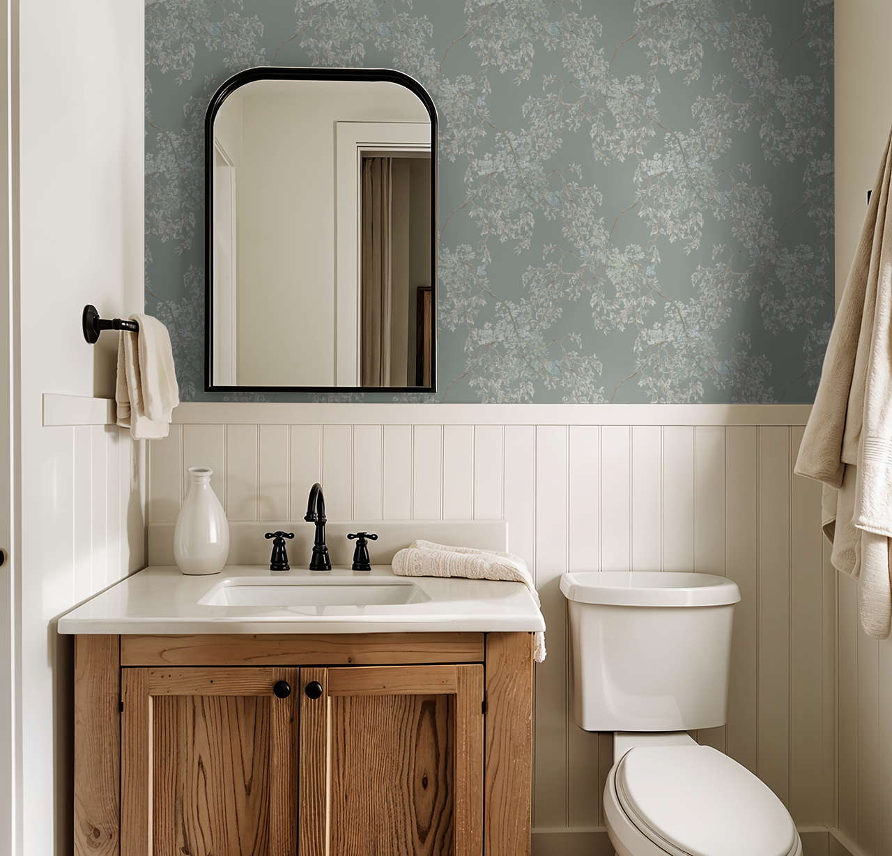 Bathroom with wooden vanity, sink, and toilet against a floral wallpapered wall.
