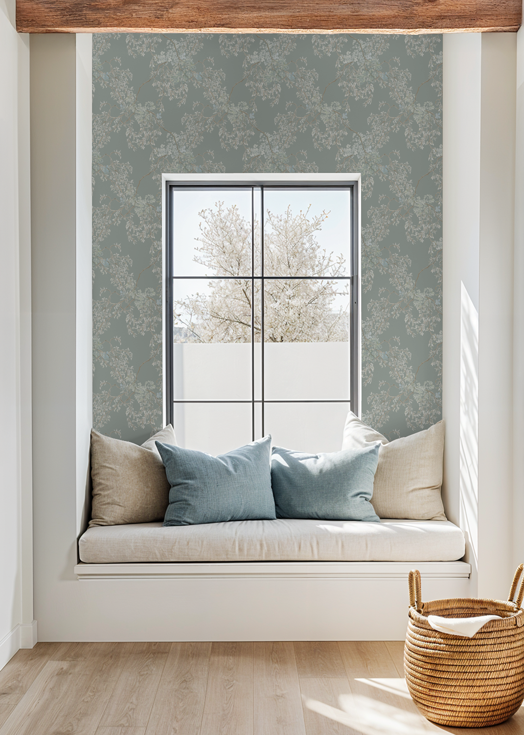 Window seat with cushions and a woven basket in a room with floral wallpaper.