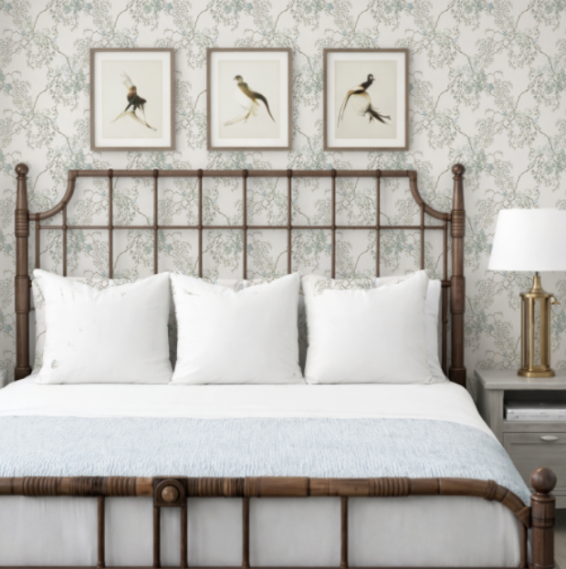 Bedroom with a wooden headboard, white bedding, and framed artwork on the wall.