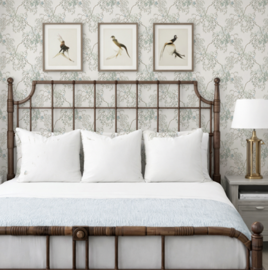 Bedroom with a wooden headboard, white bedding, and framed artwork on the wall.
