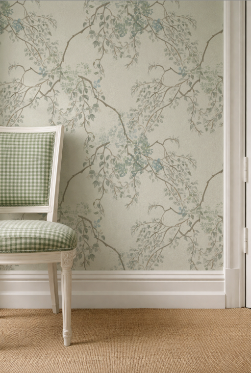 Wallpaper with floral and branch pattern in a room with a checkered chair.