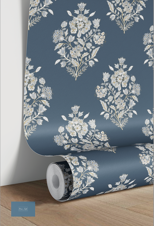 Roll of floral wallpaper with a blue background on a wooden floor.
