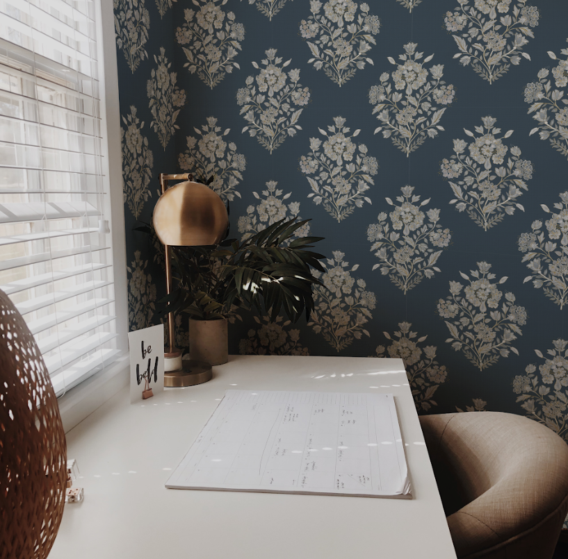 Home office with floral wallpaper, desk, and decor items.