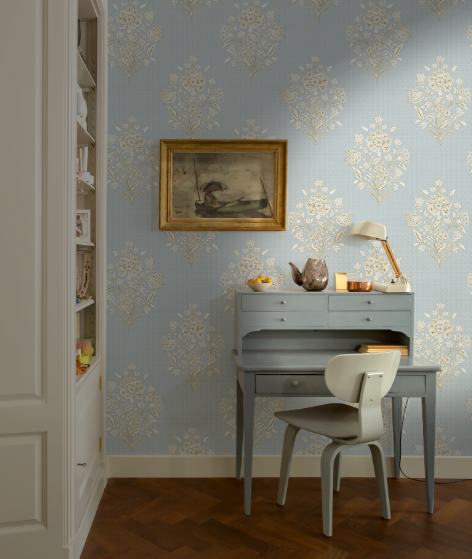 Room interior with a desk, chair, and decorative wall paper.