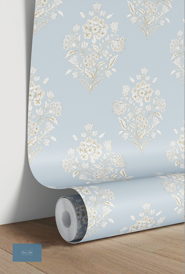Roll of floral wallpaper with a light blue background on a wooden floor.