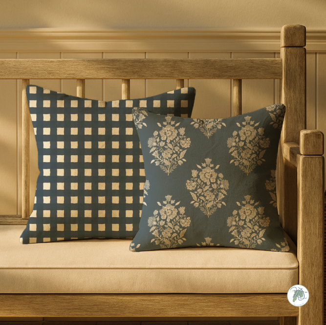 Two decorative pillows on a wooden bench with a neutral background