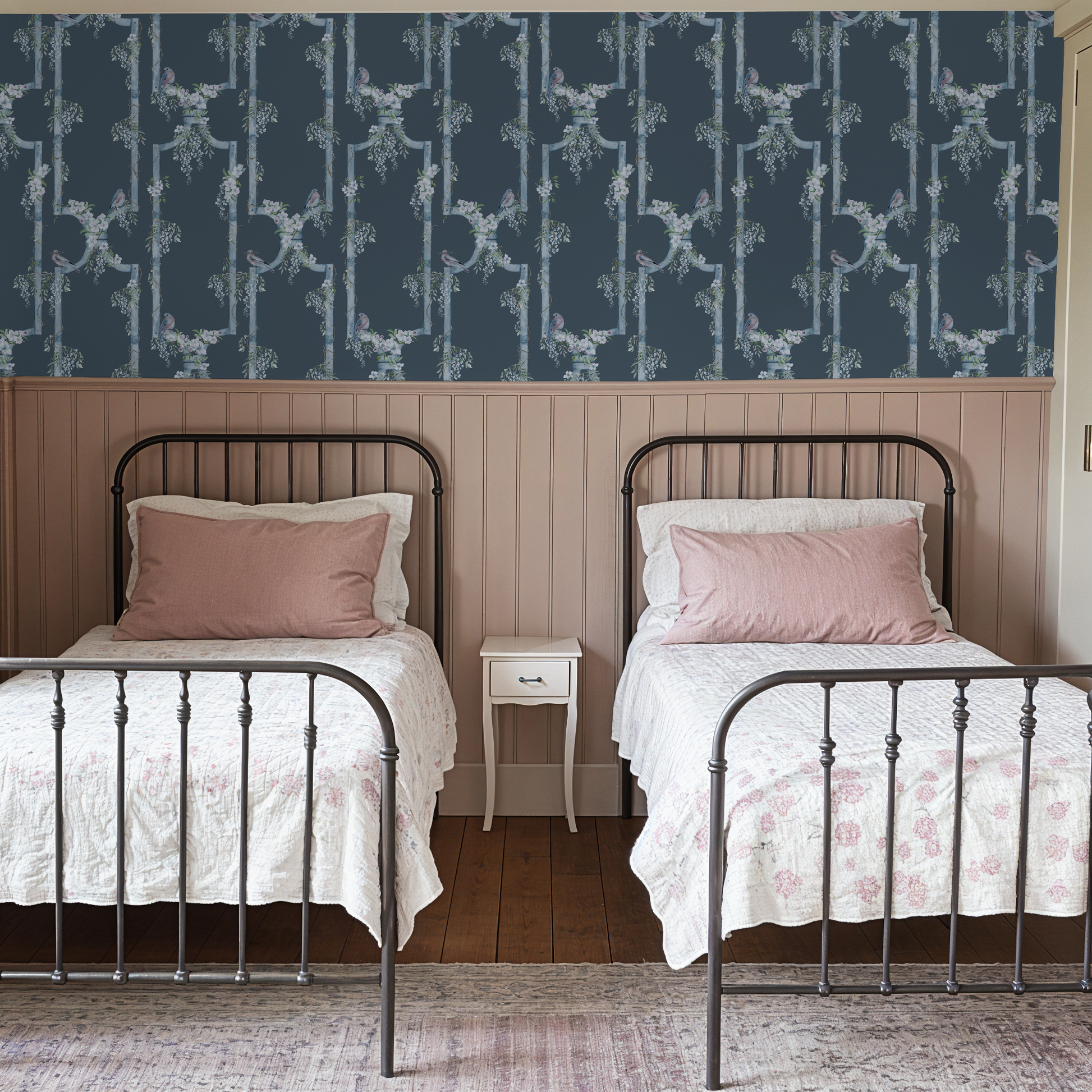 Blue bird and floral trellis wallpaper in cozy bedroom with twin beds.