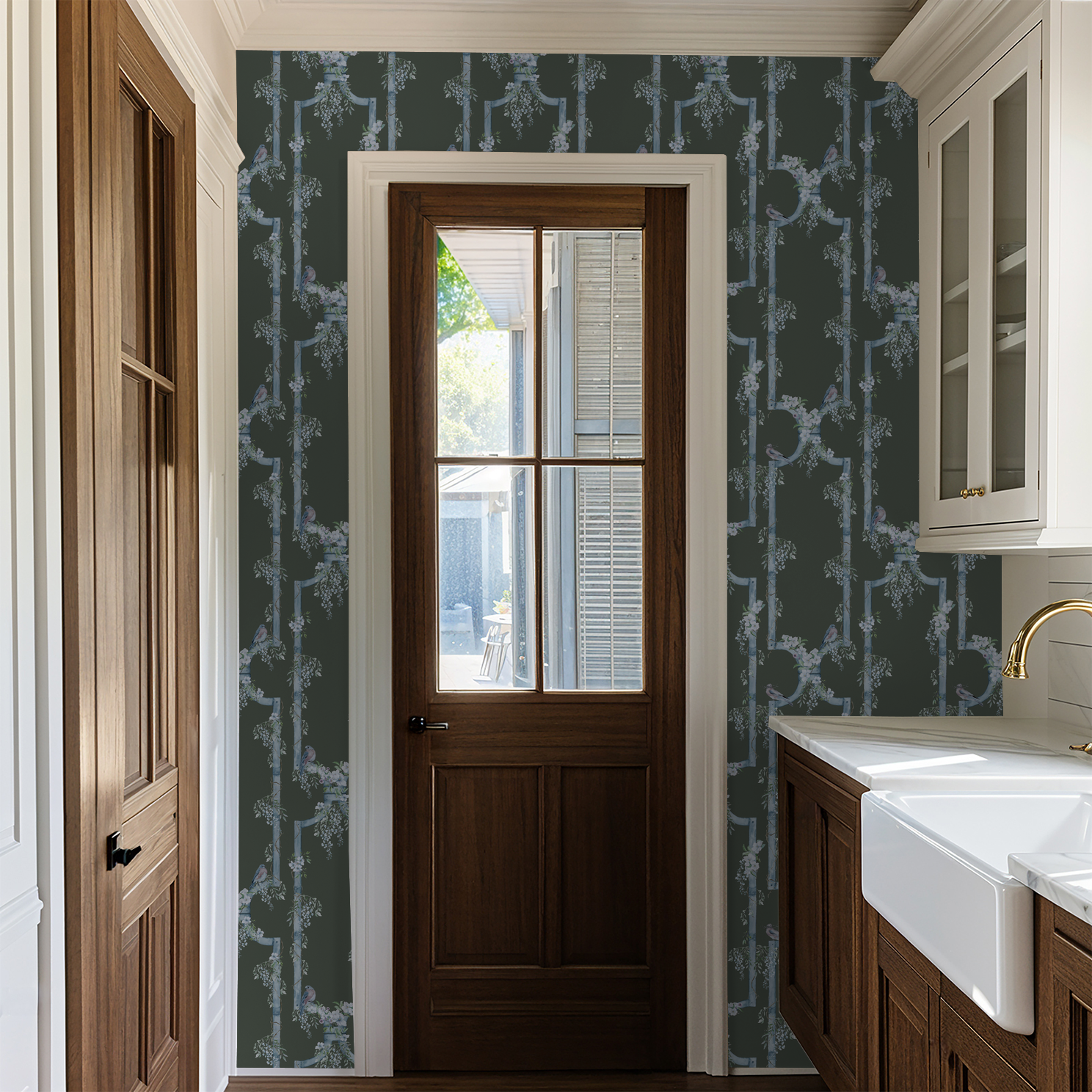 Blue bird and wisteria trellis wallpaper in a rustic kitchen with wooden door.