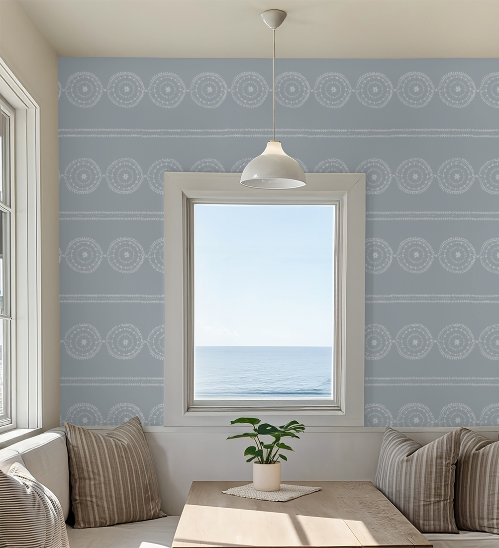 Blue medallion stripe wallpaper in coastal dining nook with ocean view.