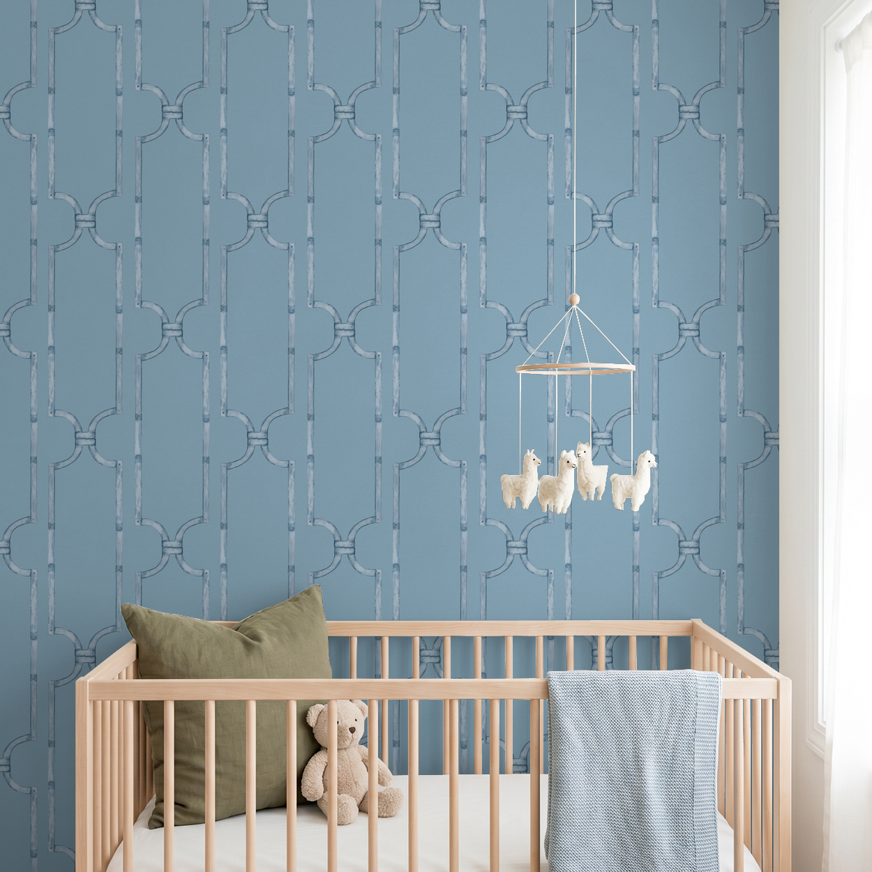 Blue trellis wallpaper in nursery with crib and plush toys.