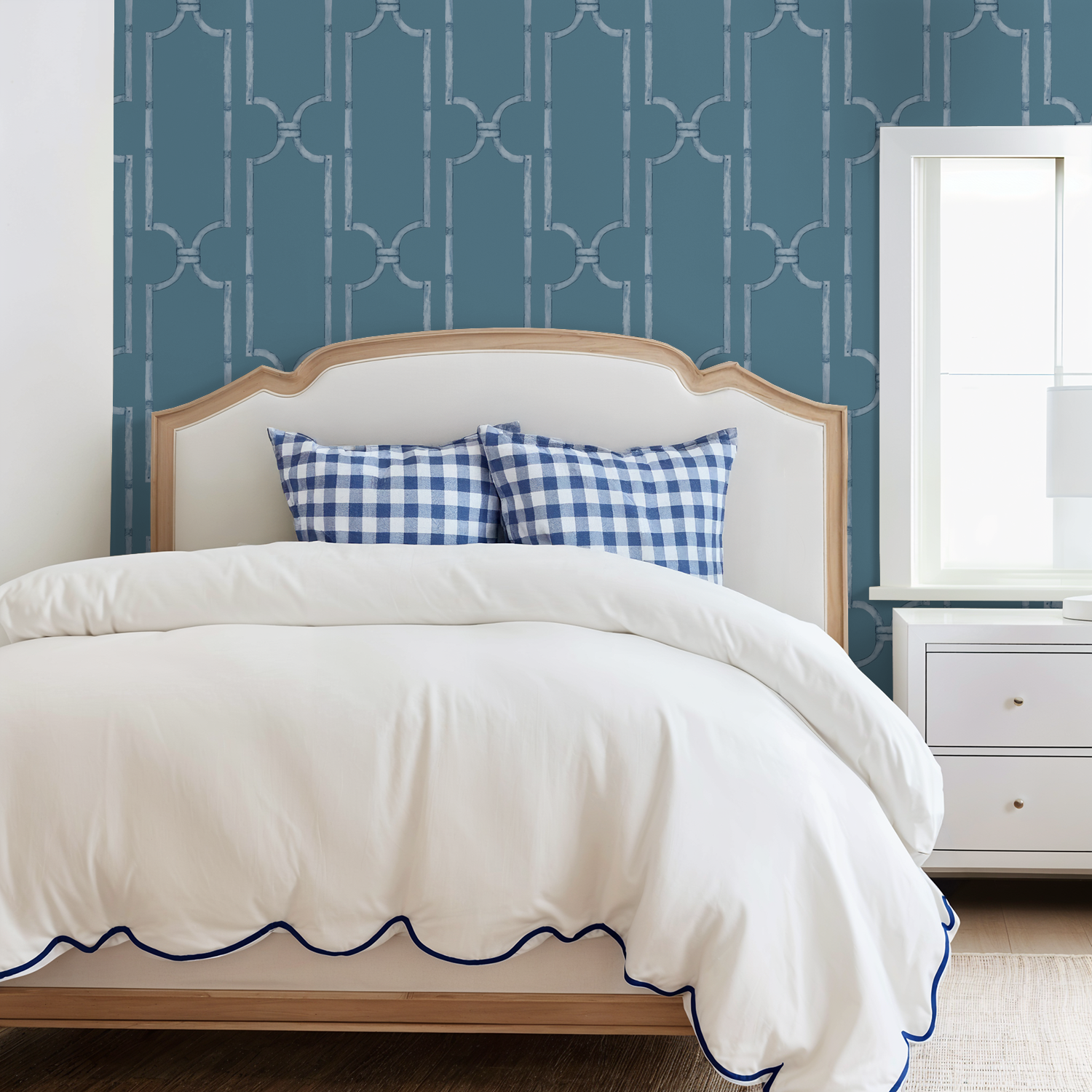 Blue wood trellis wallpaper in bedroom with white bed and checkered pillows.