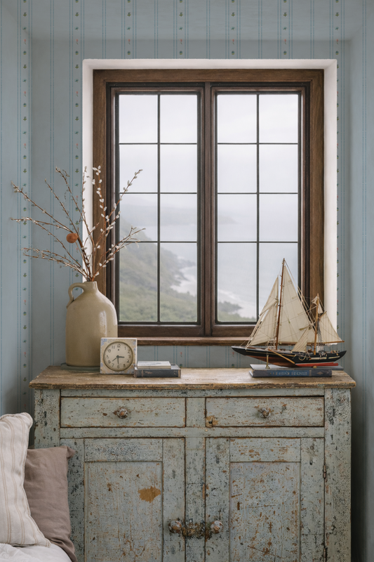 Vintage-style room with a wooden sideboard, window, and decorative items.