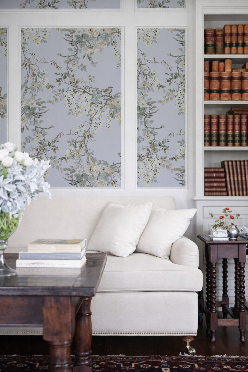 Living room with a white sofa, wooden coffee table, and bookshelf with books.