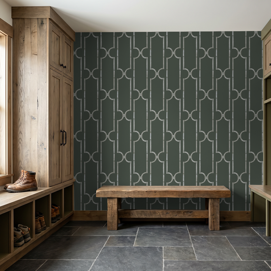 Dark gray trellis wallpaper in rustic mudroom with wooden bench and cabinets.