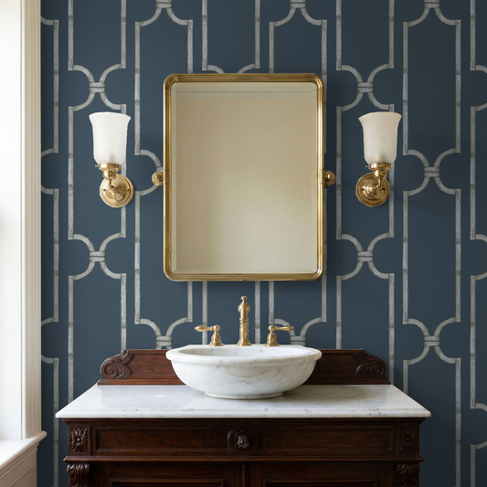 Deep blue trellis wallpaper in elegant bathroom with marble sink and gold mirror.