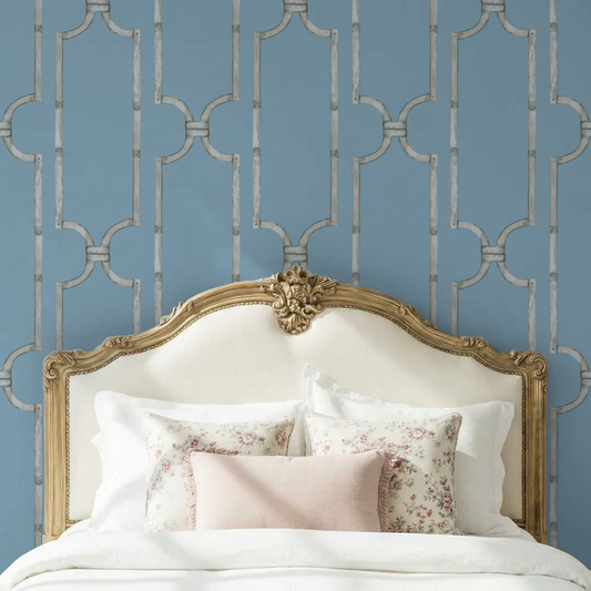 Elegant trellis pattern wallpaper in soft blue behind ornate bed