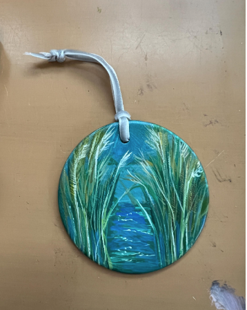 Round decorative item with grass pattern on a beige background