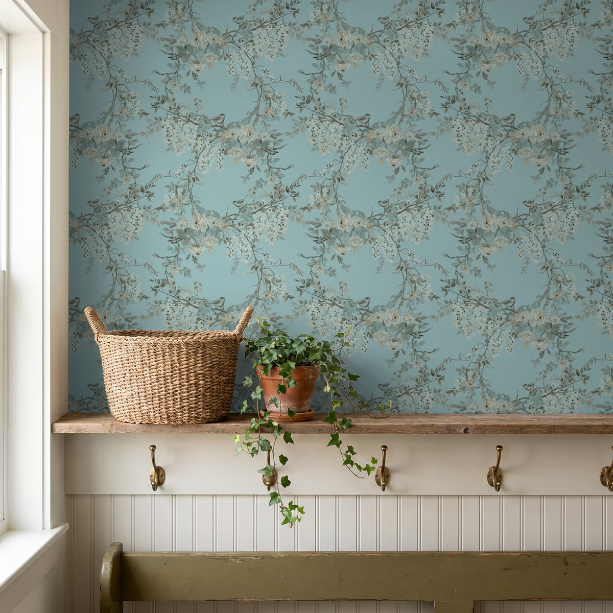 Floral wallpaper with birds on sky-blue background in rustic room setting.