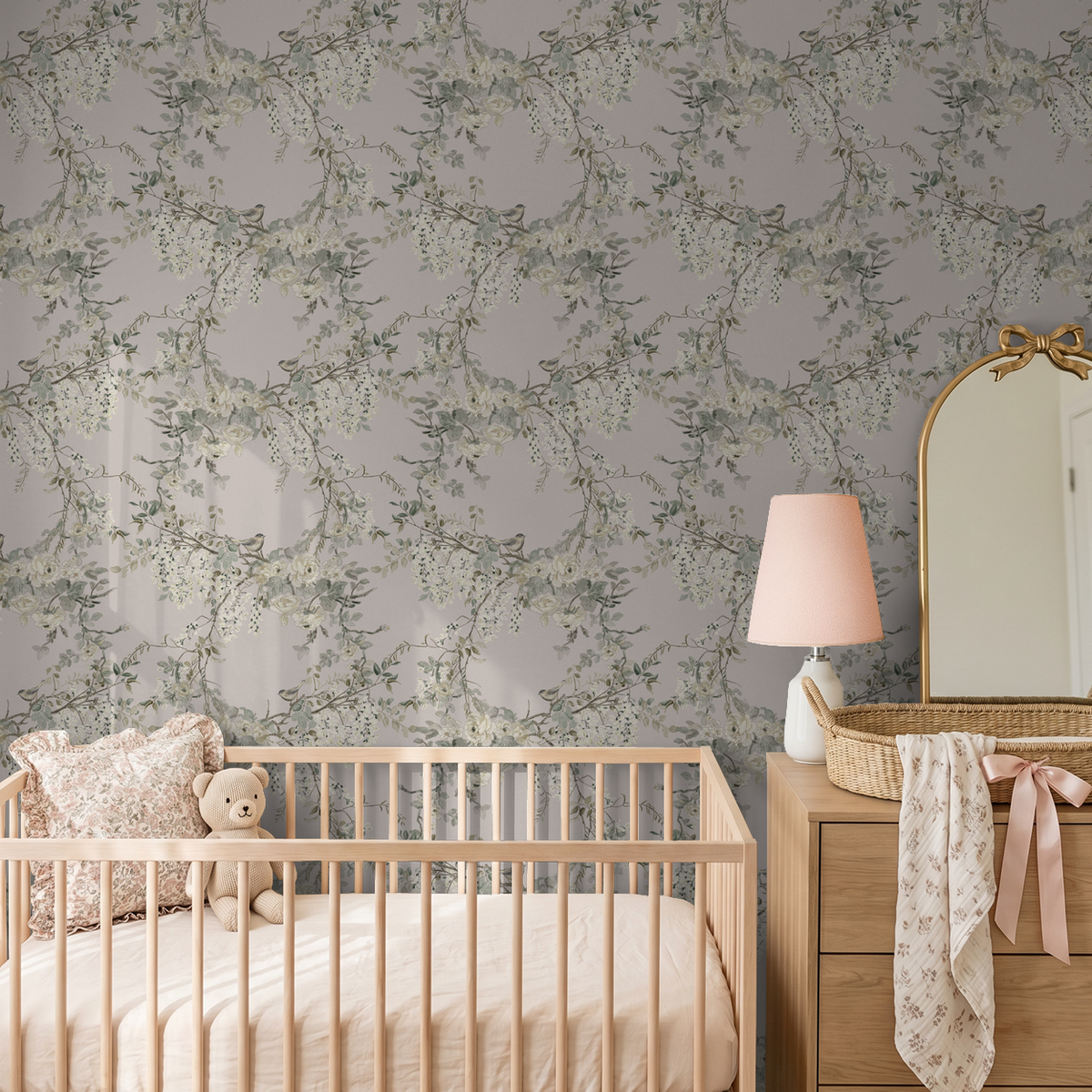 Floral wallpaper with branches in nursery setting, soft pink and green tones.