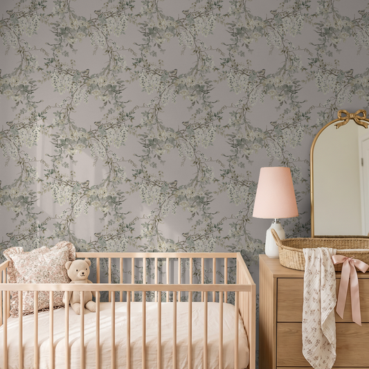 Floral wallpaper with branches in nursery setting, soft pink and green tones.